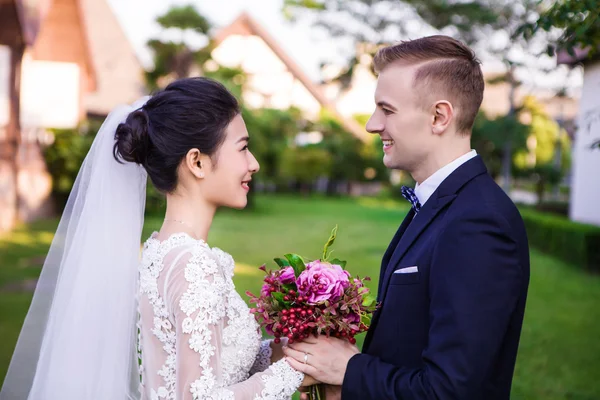 Sonriente boda pareja celebración ramo — Foto de Stock