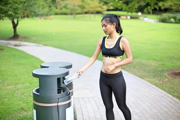 Woman doing recycling in park after run — ストック写真