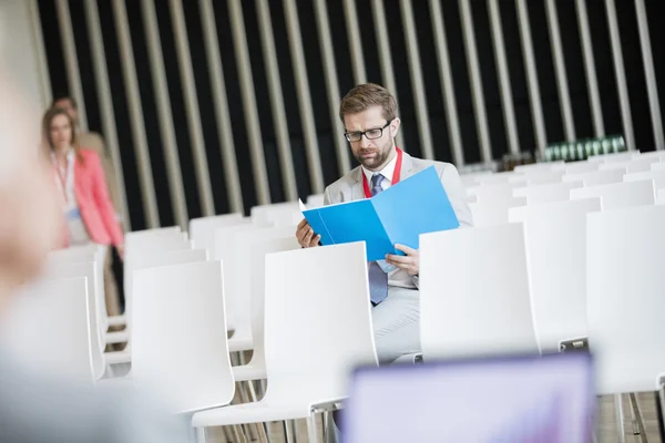 Businessman arquivo de leitura no centro de convenções — Fotografia de Stock