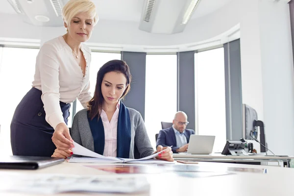 Businesswomen reading book at office — Stock Photo, Image