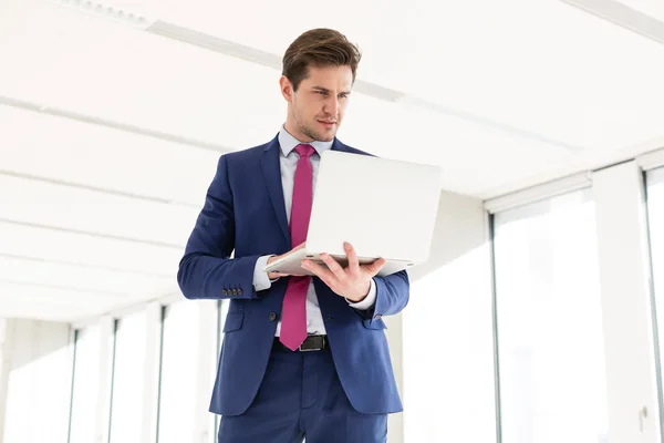 Homme d'affaires utilisant un ordinateur portable dans un nouveau bureau — Photo