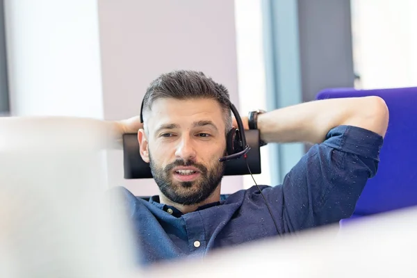 Empresário usando fone de ouvido no escritório — Fotografia de Stock