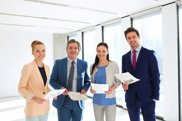 Pessoas de negócios sorridentes com documentos no escritório — Fotografia de Stock