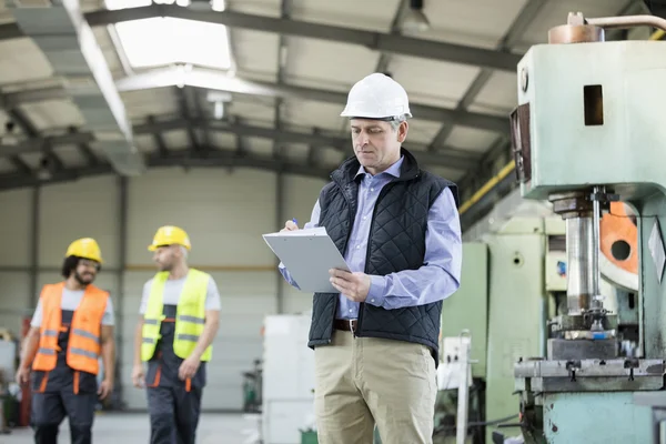 Inspector masculino escribiendo en portapapeles — Foto de Stock