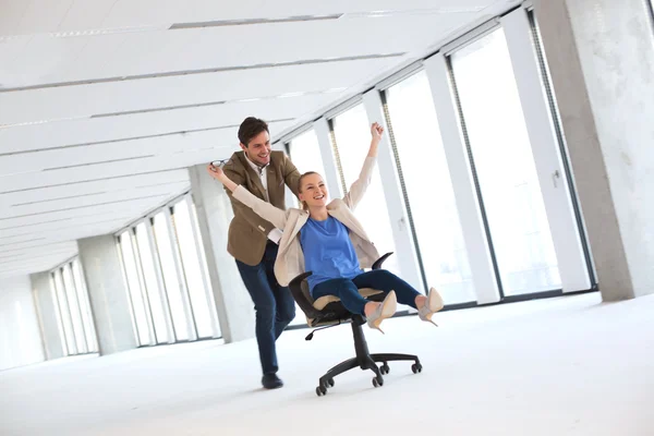 Empresário empurrando mulher colega na cadeira — Fotografia de Stock