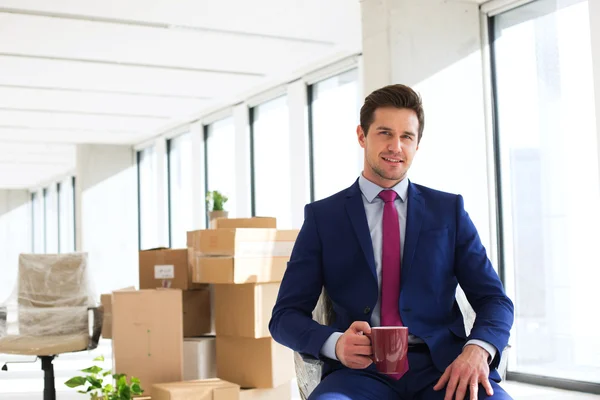 Businessman having coffee in new office — Stock Photo, Image