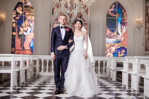 Confident wedding couple at church — Stockfoto