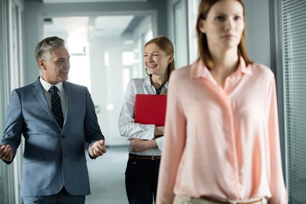 Empresario y mujer de negocios hablando mientras camina en la oficina —  Fotos de Stock