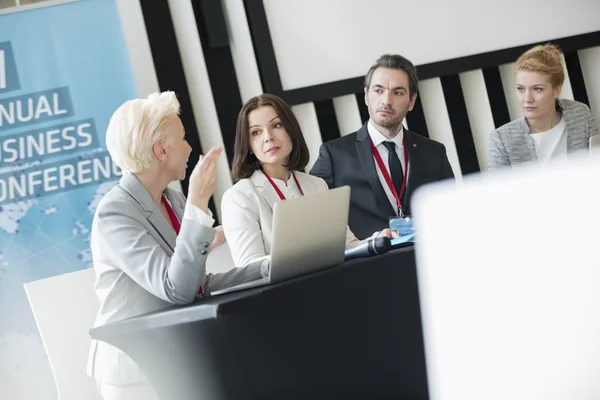 Business people talking in seminar hall — Stock Photo, Image