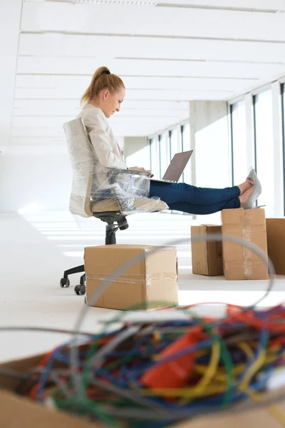 Businesswoman using laptop in new office — Stock Photo, Image