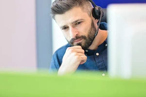 Doordachte zakenman hoofdtelefoon dragen op kantoor — Stockfoto