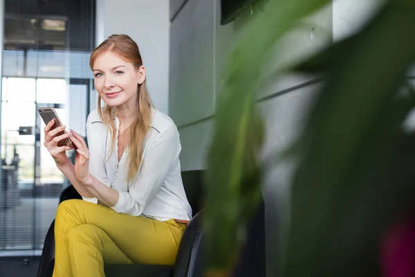 Geschäftsfrau mit Handy im Büro — Stockfoto