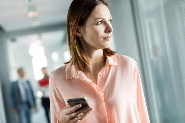 Affärskvinna håller smartphone — Stockfoto