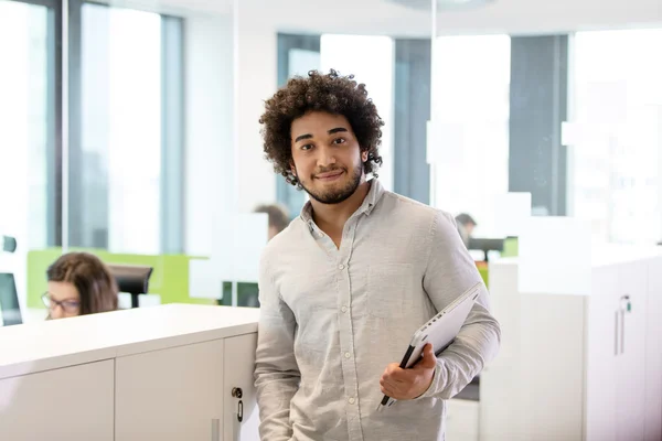 Jovem empresário segurando laptop no escritório — Fotografia de Stock