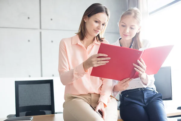 Businesswomen reading file in office — Stock Photo, Image