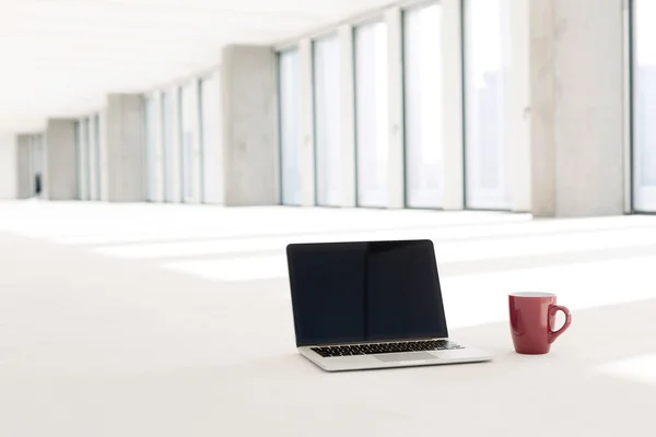 Ноутбук и красная чашка кофе — стоковое фото