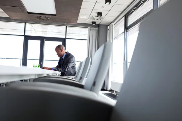 Hombre de negocios sentado en la mesa en la sala de juntas — Foto de Stock