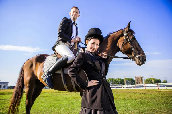 Donna in piedi accanto all'uomo seduto a cavallo — Foto Stock