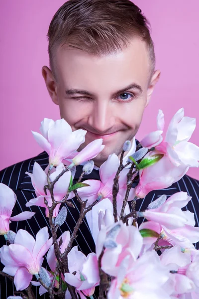 Bridegroom with artificial flowers winking — Stock Photo, Image