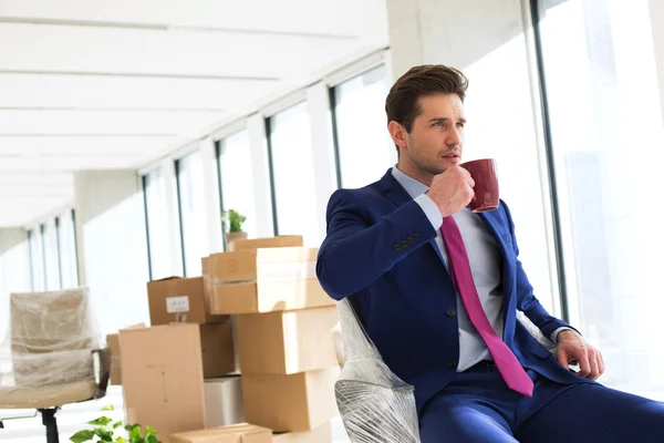 Businessman having coffee in new office — Stock Photo, Image