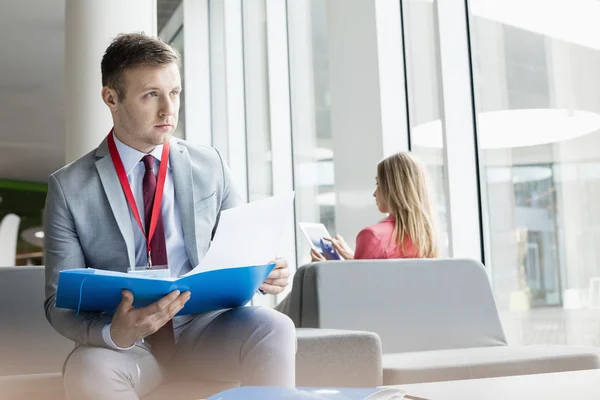 Thoughtful businessman sitting at lobby — Stock Photo, Image