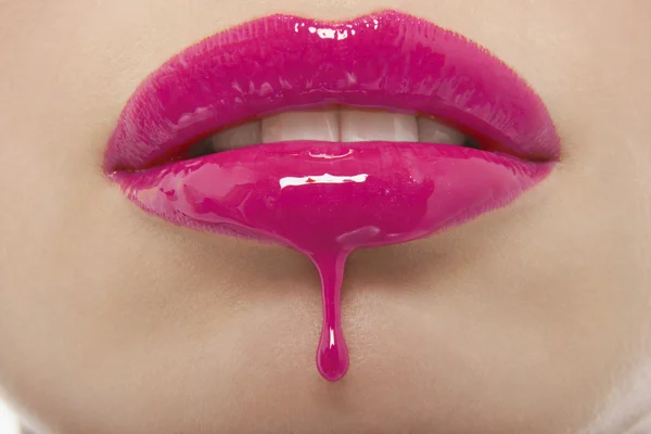 Rosafarbener Lipgloss tropft von Frauenlippen — Stockfoto