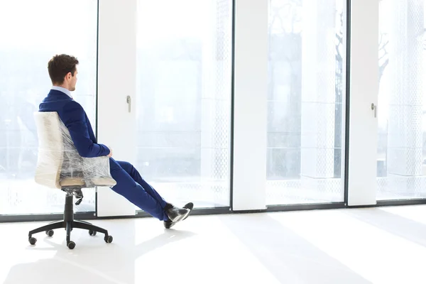 Бизнесмен сидит на стуле в новом офисе — стоковое фото