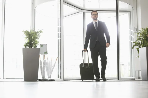 Empresário com bagagem entrando no centro de convenções — Fotografia de Stock