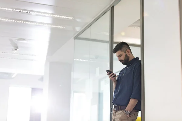 Zakenman met mobiele telefoon op kantoor — Stockfoto