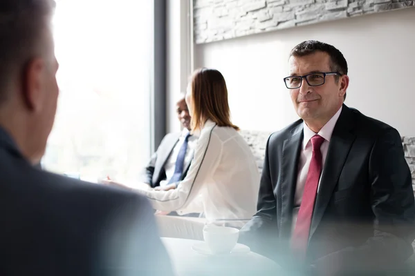 Rijpe zakenman met collega's in de cafetaria van het kantoor — Stockfoto