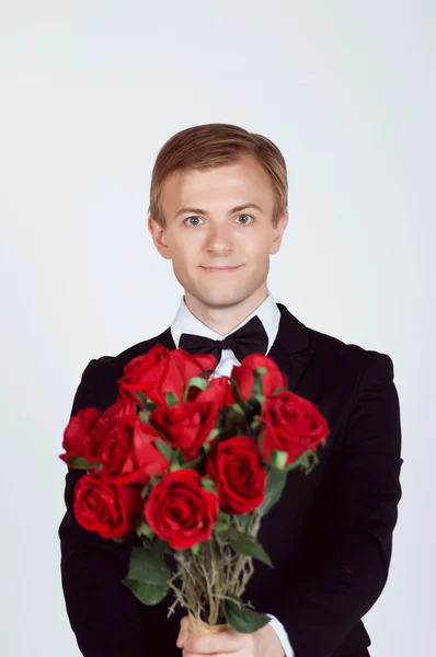 Handsome Groom holding red roses — Stock Photo, Image