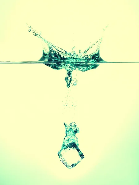 Cubo de gelo salpicando na água — Fotografia de Stock