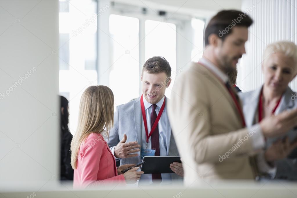 businessman discussing with colleague in convention center 