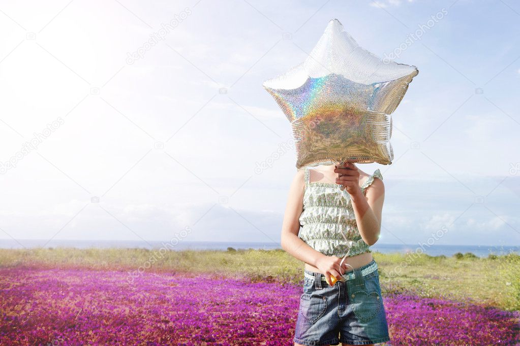 preadolescent girl with star shaped balloon 