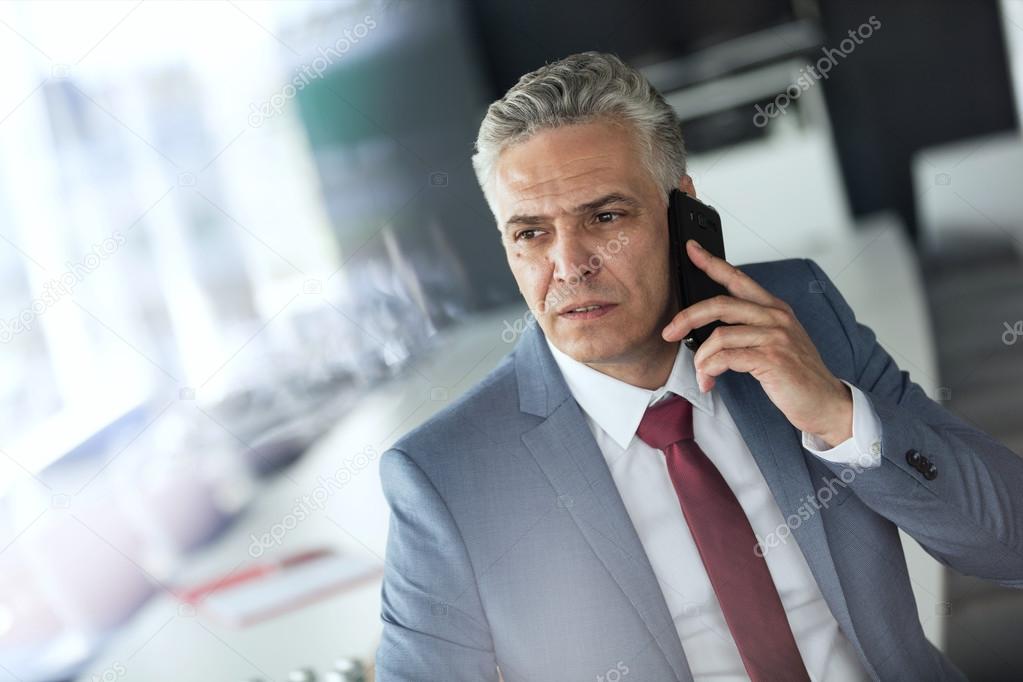 mature businessman talking on mobile phone 