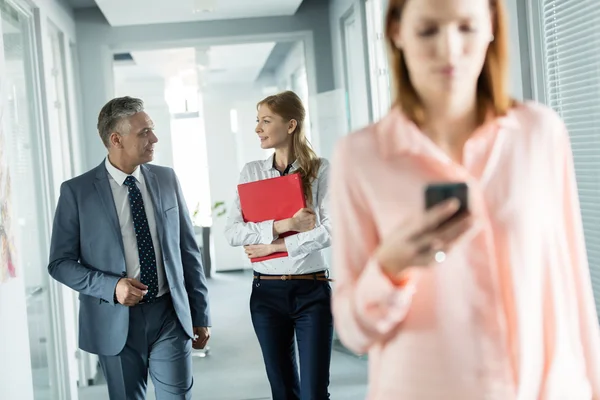 Les gens d'affaires marchant dans le couloir de bureau — Photo