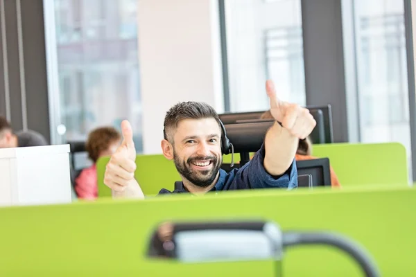 Szczęśliwy biznesmen skrzyżowane kciuk w górę w biurze — Zdjęcie stockowe