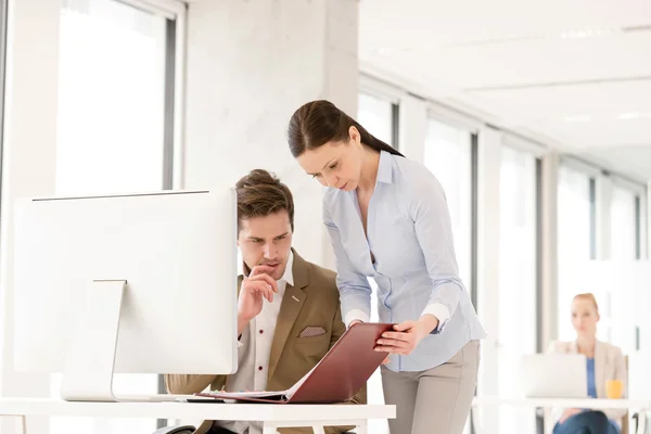 Zakenvrouw en zakenman aan het computerbureau in kantoor — Stockfoto