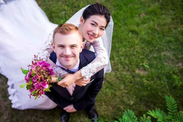 Verheugd huwelijksfeest paar permanent op veld — Stockfoto