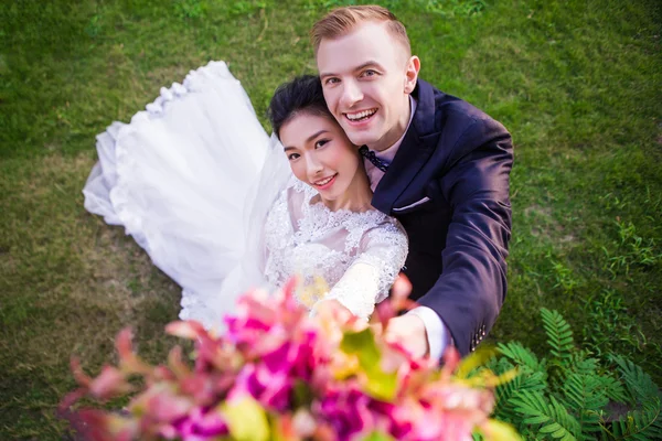 Casal de casamento feliz no campo gramado — Fotografia de Stock
