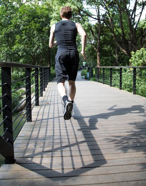 Человек бежит по мосту — стоковое фото