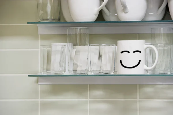 Tasse avec signe souriant sur l'étagère — Photo
