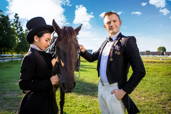 Уверенный мужчина, стоящий с лошадью и женщиной — стоковое фото
