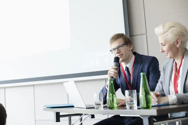 Businessman speaking through microphone — Stock Photo, Image