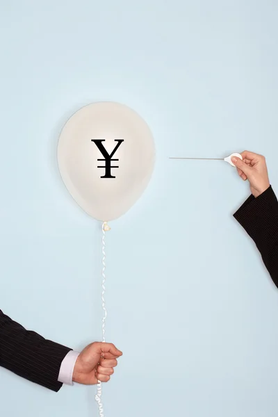 Hands holding balloon with yuan sign — Stock Photo, Image