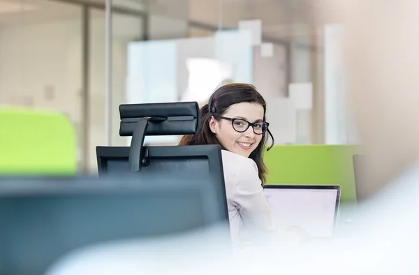 Mujer de negocios con auriculares en la oficina —  Fotos de Stock