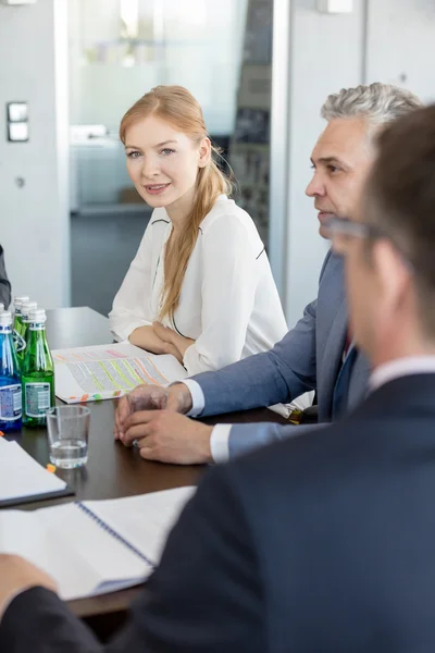 Femme d'affaires avec collègues masculins en salle de conférence — Photo