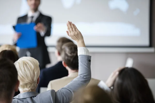 Zakenvrouw hand verhogen tijdens seminar — Stockfoto