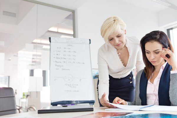 Бизнес-женщины рассматривают проект за столом в офисе
 