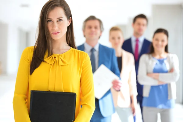 Donna d'affari con team in background in ufficio — Foto Stock